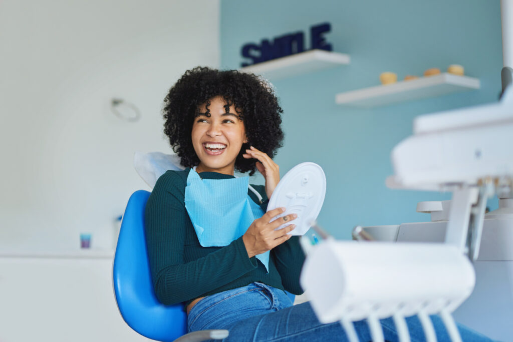 Shot of a young woman admiring her teeth after having a dental procedure done