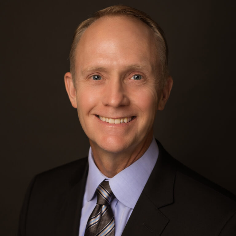 Orthodontist Dr. Stephen R. Nelson smiling in a suit and tie